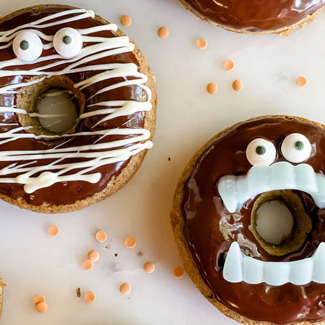 Photo of pumpkin donuts decorated as vampires and mummies
