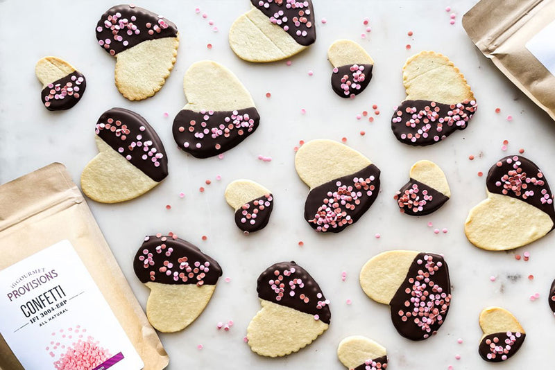 Heart-shaped paleo Valentine cookies covered with Tumaco Luker Chocolate and pink and red Confetti Sugar